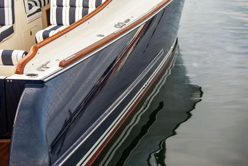 Slide: The Image of 2024 Hinckley 35 boat cruising on calm waters with American flag. - 58