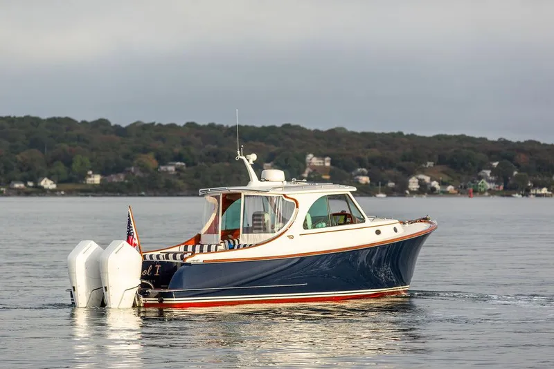 Slide: The Image of 2024 Hinckley 35 boat cruising on water with American flag, scenic background. - 8