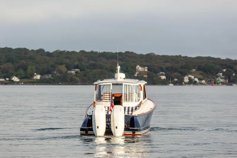 Slide: The Image of 2024 Hinckley 35 boat anchored in clear, shallow water under a blue sky. - 9
