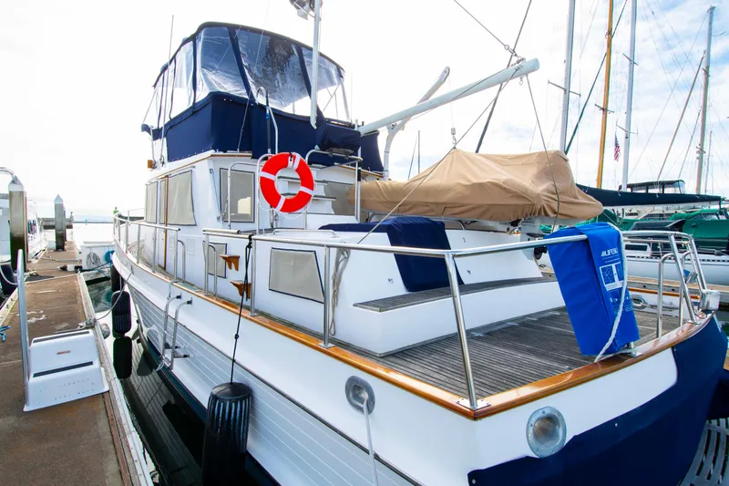 Slide: The Image of Grand Banks 42 Classic yacht, 2000 model, docked with blue canopy and life preserver. - 12