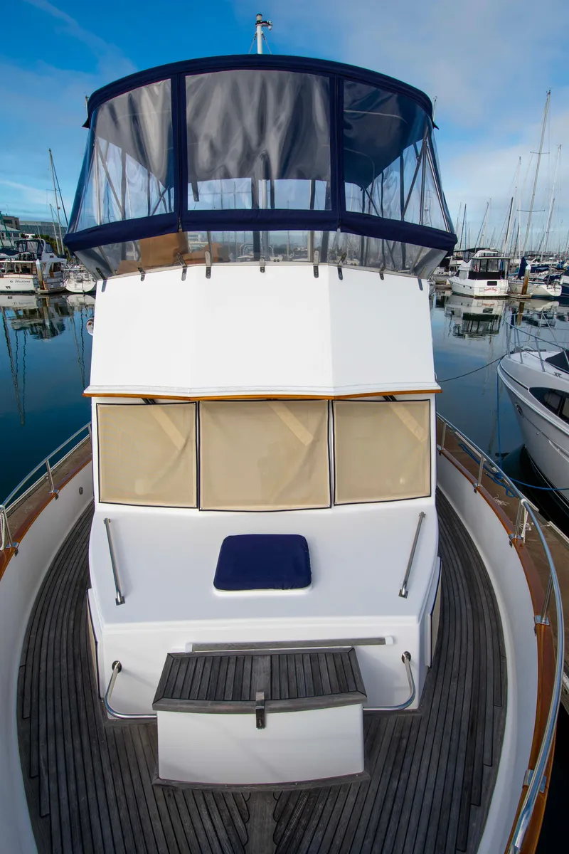 Slide: The Image of Grand Banks 42 Classic 2000 yacht docked in marina, featuring spacious deck and enclosed flybridge. - 15