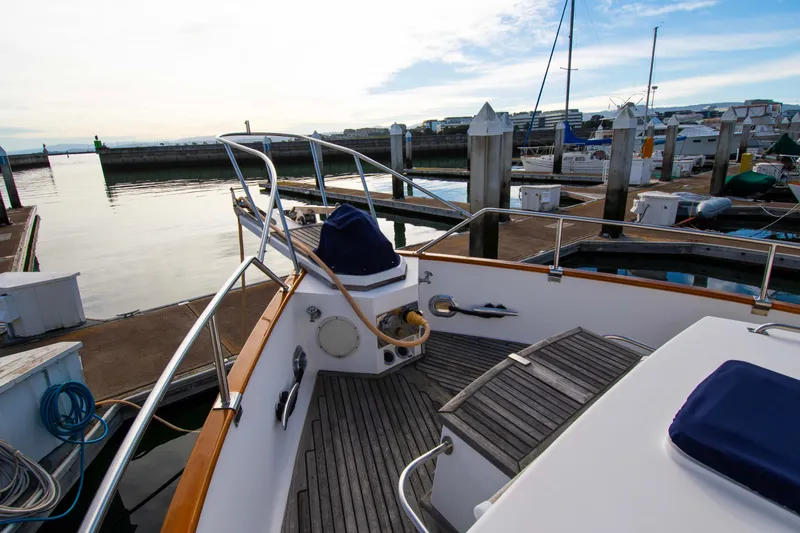 Slide: The Image of Grand Banks 42 Classic yacht docked at marina, showcasing deck and serene waterfront view. - 16