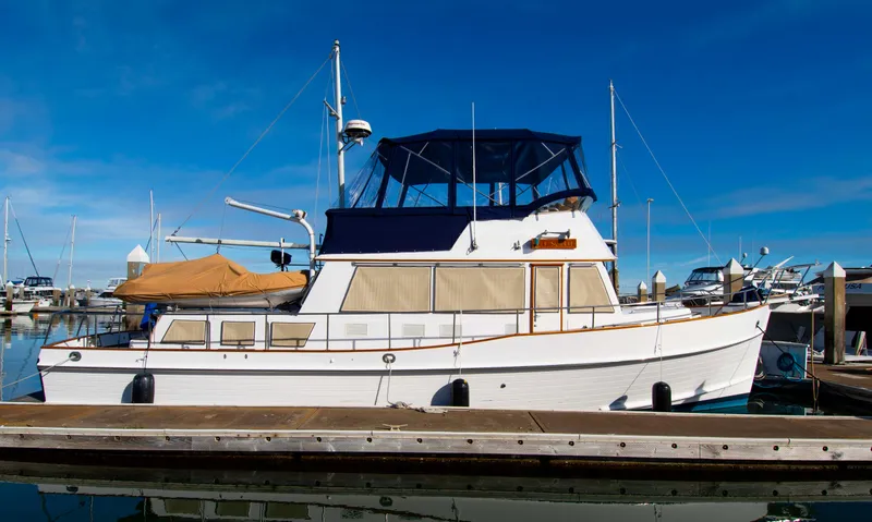 Slide: The Image of Grand Banks 42 Classic yacht, 2000 model, docked at marina under clear blue sky. - 19