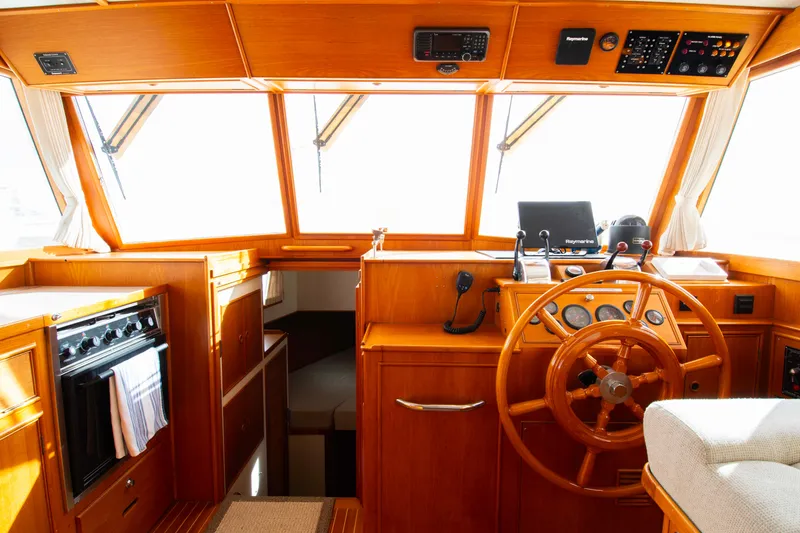 Slide: The Image of Interior helm of 2000 Grand Banks 42 Classic yacht with wooden steering wheel and navigation equipment. - 34