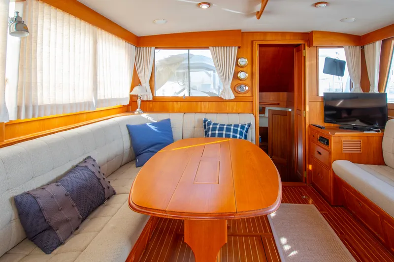 Slide: The Image of Interior of 2000 Grand Banks 42 Classic yacht with cozy seating and wooden table. - 37