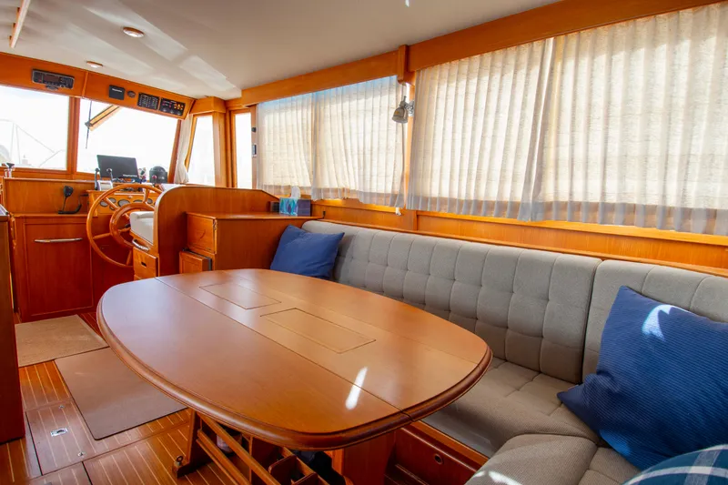 Slide: The Image of Interior of 2000 Grand Banks 42 Classic yacht with wooden table and cushioned seating. - 39