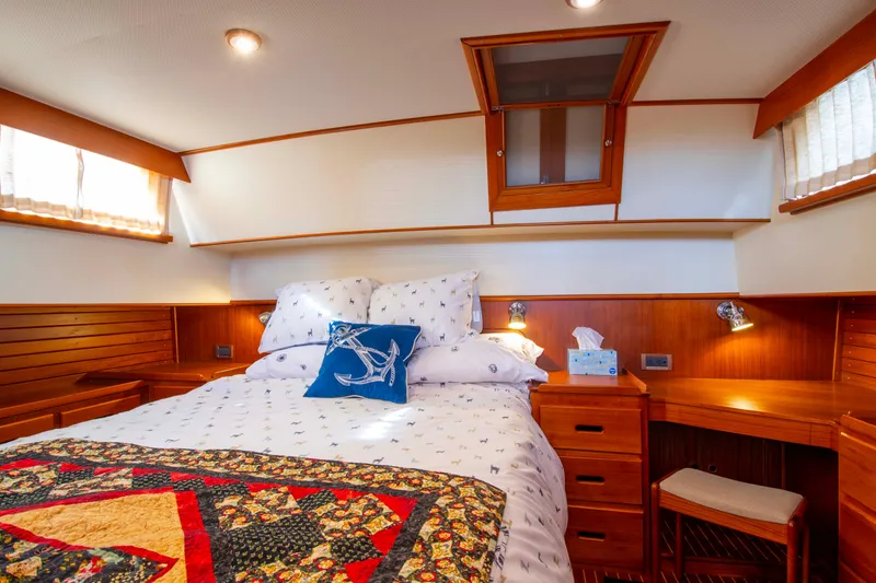 Slide: The Image of Cozy bedroom in 2000 Grand Banks 42 Classic yacht with wood accents and nautical decor. - 44