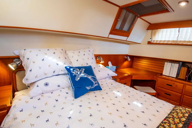 Slide: The Image of Cozy bedroom in 2000 Grand Banks 42 Classic yacht with nautical-themed decor. - 46