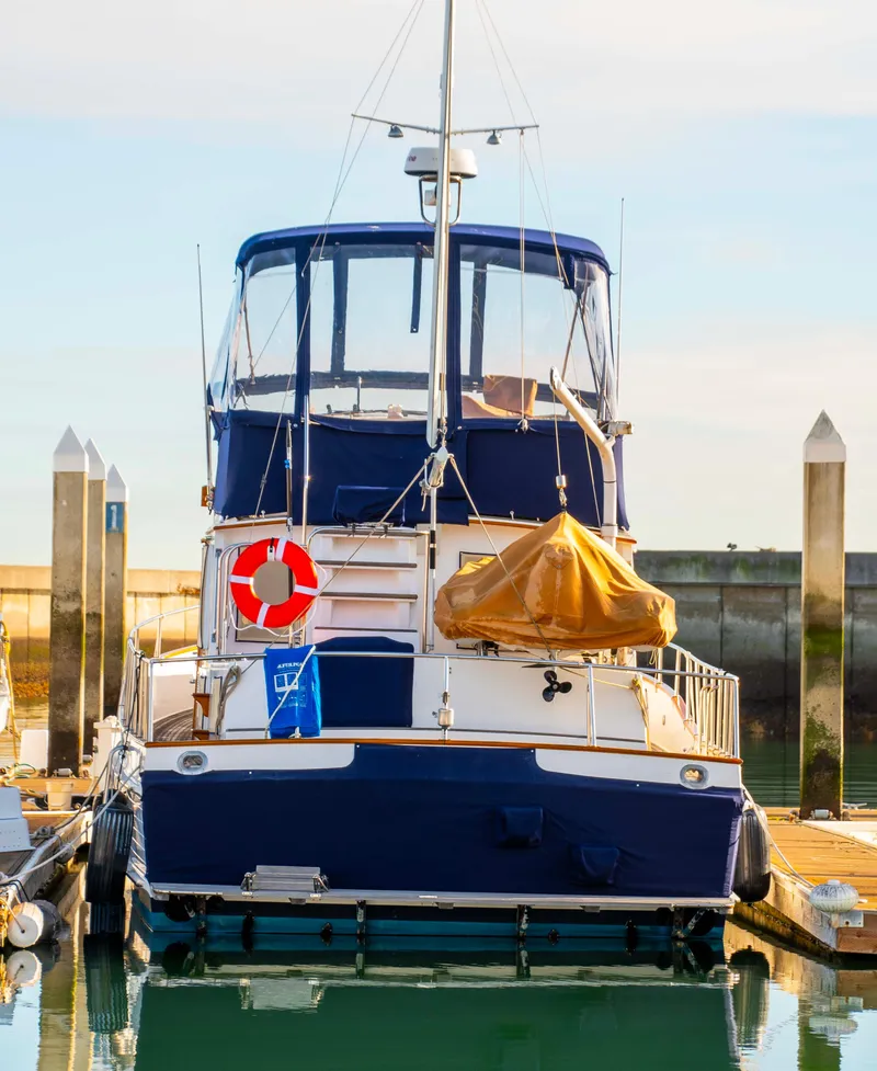 Slide: The Image of Grand Banks 42 Classic yacht, 2000 model, docked at marina with blue and white exterior. - 48