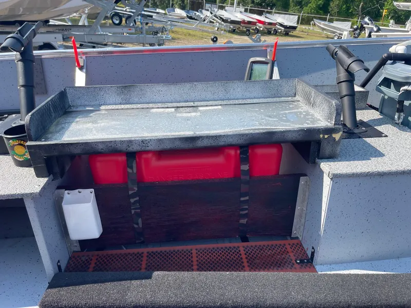 Slide: The Image of 2025 Lund SSV-16 Tiller boat interior with storage compartment and red fuel tank. - 12