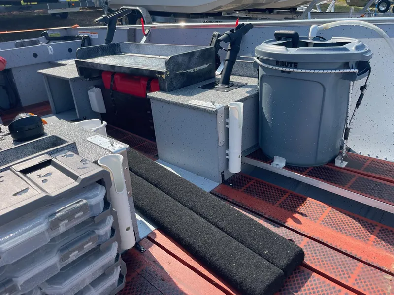 Slide: The Image of 2025 Lund SSV-16 Tiller boat interior with storage compartments and fishing gear. - 13