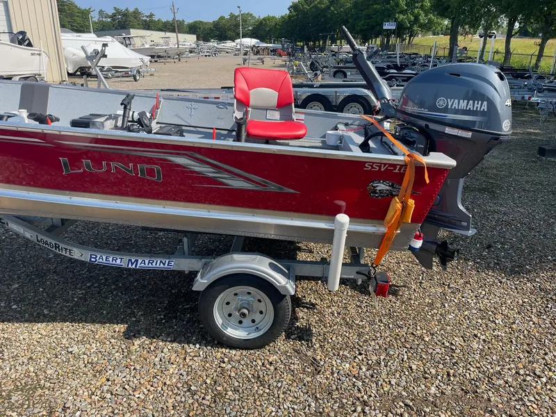 Slide: The Image of 2025 Lund SSV-16 Tiller boat with Yamaha motor on a trailer in a marina. - 3
