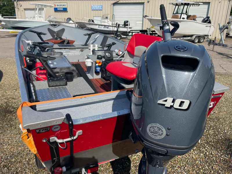 Slide: The Image of 2025 Lund SSV-16 Tiller boat with 40 HP motor, red interior, parked outdoors. - 5