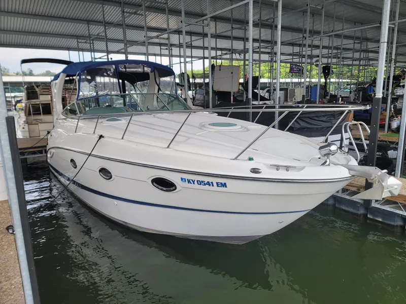 The Image of 2004 Maxum 3100 SE boat docked in a covered marina, side view. - 0