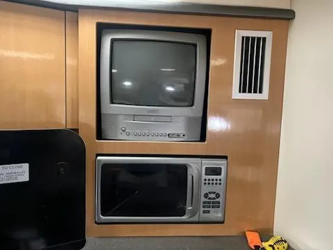 Slide: The Image of 2004 Maxum 3100 SE interior with built-in TV and microwave. - 7