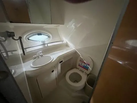 Slide: The Image of 2004 Maxum 3100 SE boat bathroom with sink, toilet, and porthole window. - 9