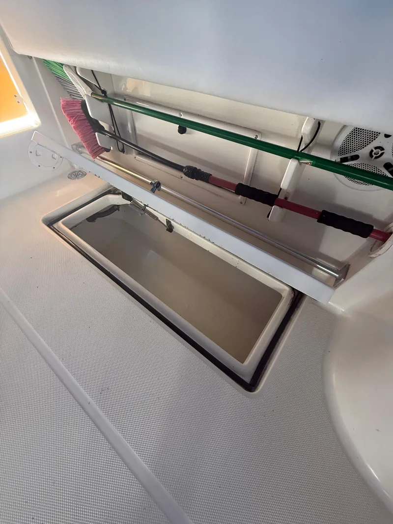 Slide: The Image of 2003 Hydra-Sports Vector 2800 WA boat storage compartment with fishing rods and cleaning tools. - 13