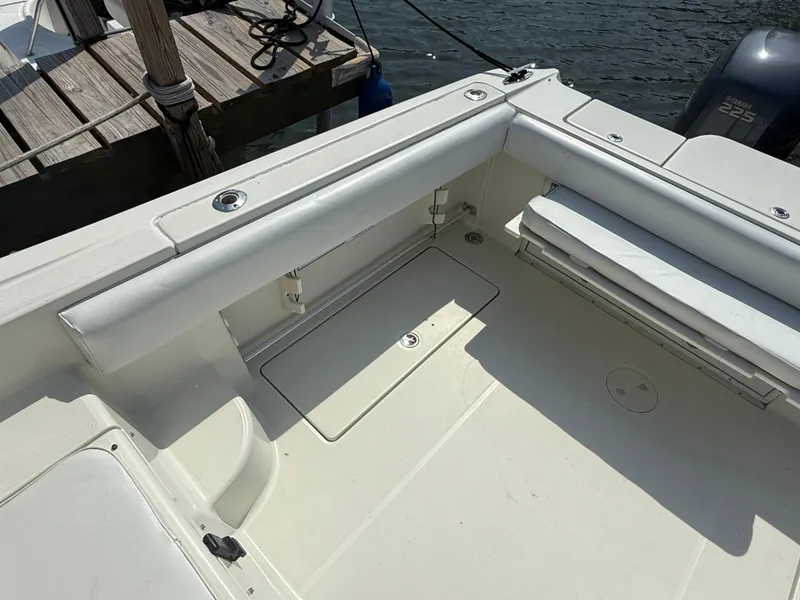 Slide: The Image of 2003 Hydra-Sports Vector 2800 WA boat interior with seating and storage, docked by water. - 14