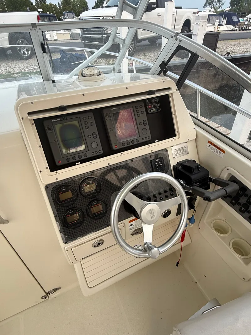 Slide: The Image of 2003 Hydra-Sports Vector 2800 WA boat dashboard with steering wheel and navigation instruments. - 20