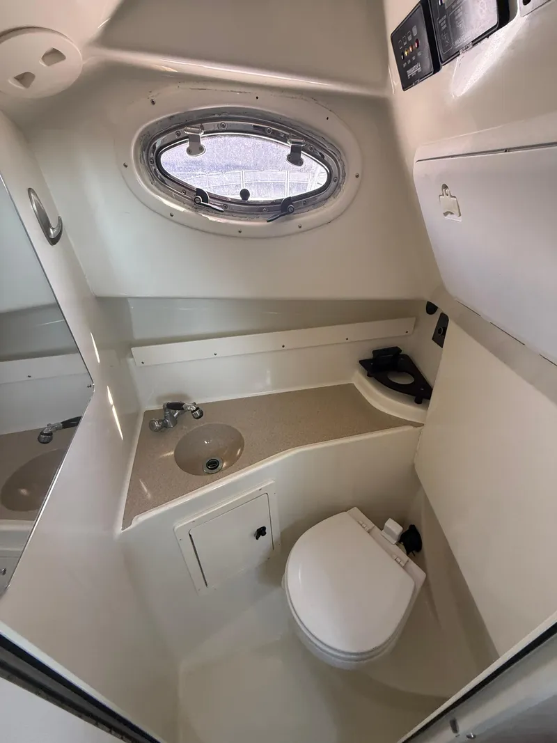 Slide: The Image of 2003 Hydra-Sports Vector 2800 WA boat bathroom with sink, toilet, and porthole window. - 31