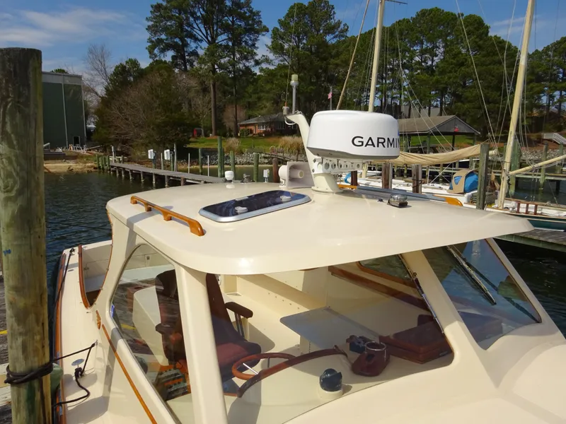 Slide: The Image of 1995 Hinckley Picnic Boat Classic docked, featuring Garmin equipment, surrounded by trees and water. - 10