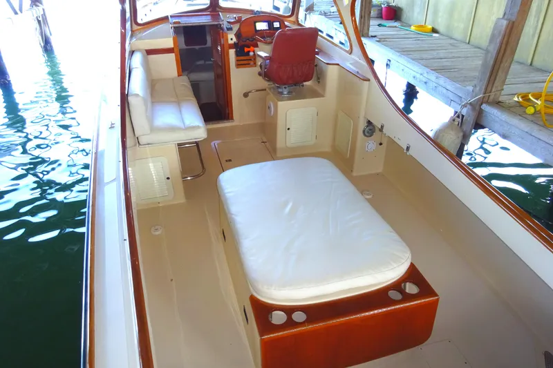 Slide: The Image of 1995 Hinckley Picnic Boat Classic interior with seating and helm, docked in a marina. - 16