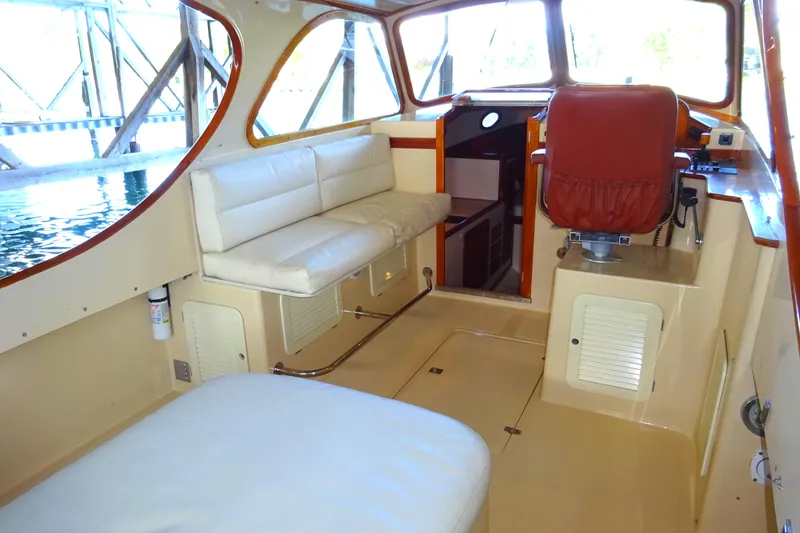 Slide: The Image of 1995 Hinckley Picnic Boat Classic interior with white seating and red captain's chair. - 19