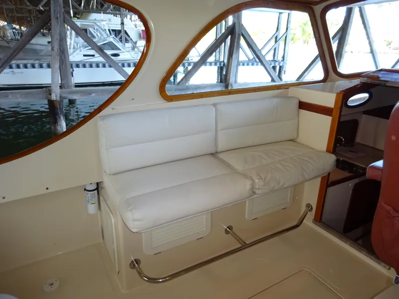 Slide: The Image of Interior of 1995 Hinckley Picnic Boat Classic with white cushioned seating. - 21