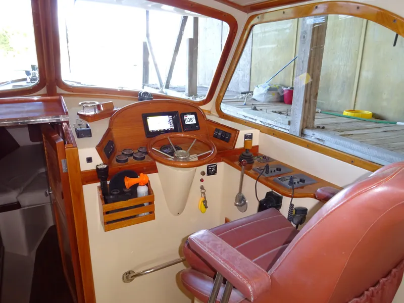 Slide: The Image of 1995 Hinckley Picnic Boat Classic helm with wooden dashboard and leather seat. - 24