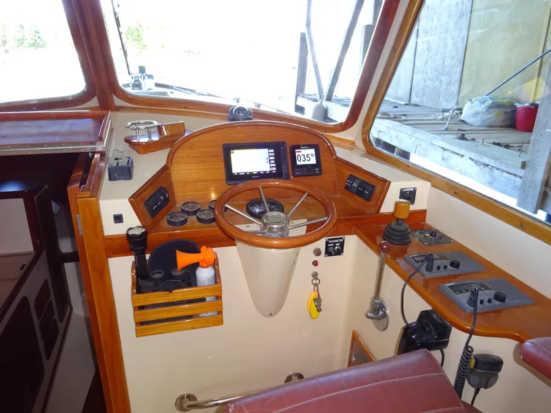 Slide: The Image of Helm of 1995 Hinckley Picnic Boat Classic with wooden accents and navigation instruments. - 25