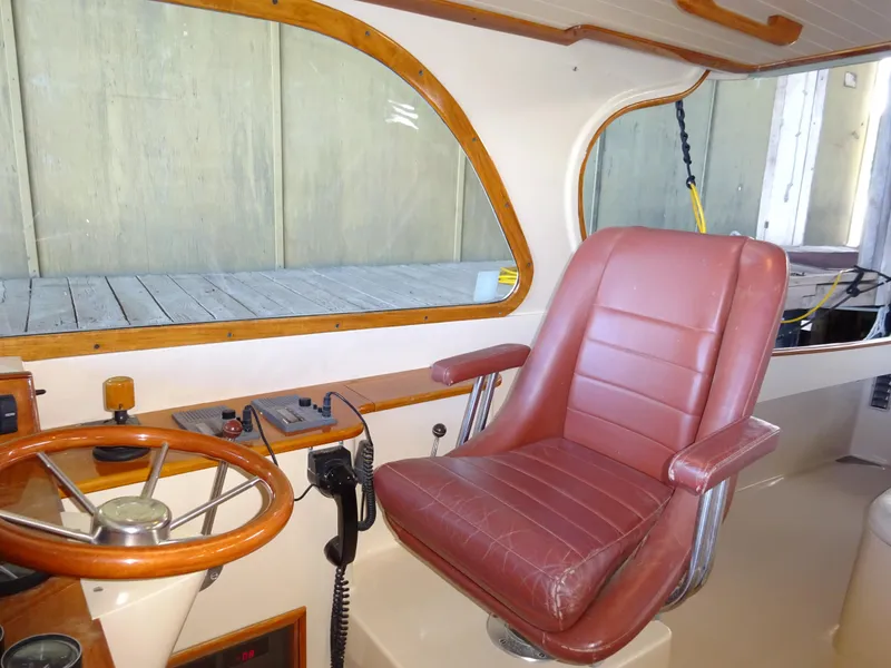 Slide: The Image of Interior of a 1995 Hinckley Picnic Boat Classic with leather captain's chair and wooden steering wheel. - 26
