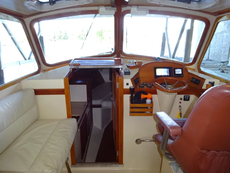 Slide: The Image of 1995 Hinckley Picnic Boat Classic interior with helm, seating, and cabin entrance. - 27