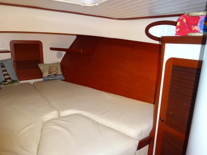 Slide: The Image of 1995 Hinckley Picnic Boat Classic cabin interior with cozy bedding and wooden accents. - 31