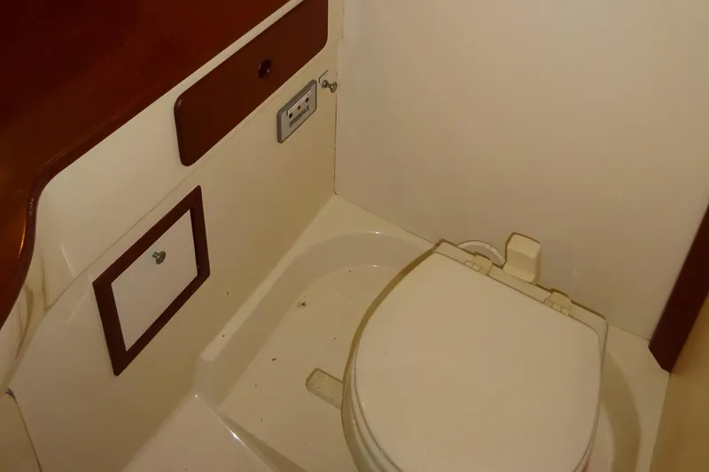 Slide: The Image of Hinckley Picnic Boat Classic 1995 interior bathroom with toilet and wooden accents. - 40