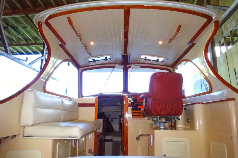 Slide: The Image of 1995 Hinckley Picnic Boat Classic interior with red captain's chair and white seating. - 41