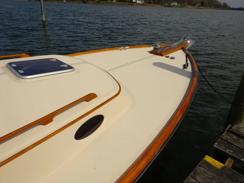 Slide: The Image of 1995 Hinckley Picnic Boat Classic docked on calm water, showcasing elegant wooden trim. - 6