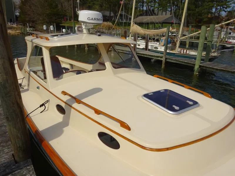Slide: The Image of 1995 Hinckley Picnic Boat Classic docked, showcasing elegant design and Garmin navigation system. - 8