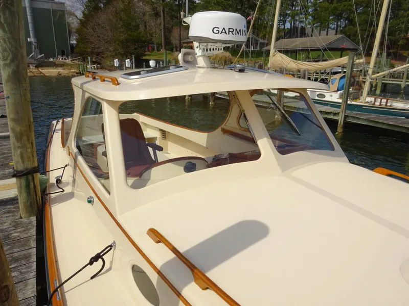 Slide: The Image of 1995 Hinckley Picnic Boat Classic docked, featuring Garmin equipment and elegant design. - 9