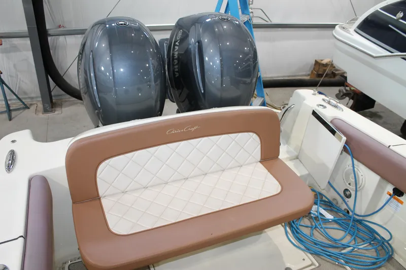 Slide: The Image of 2018 Chris-Craft Catalina 26 boat with dual engines and cushioned seating in a garage. - 10