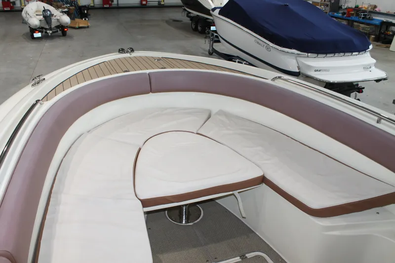 Slide: The Image of 2018 Chris-Craft Catalina 26 boat interior with cushioned seating in a storage facility. - 27