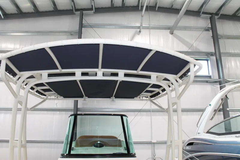 Slide: The Image of 2018 Chris-Craft Catalina 26 boat with a navy blue canopy in a storage facility. - 30