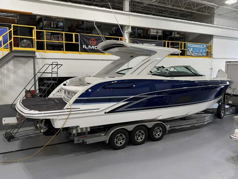 Slide: The Image of 2026 Formula 360 Crossover Bowrider I/O on trailer in a showroom. - 3