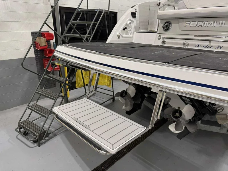 Slide: The Image of 2026 Formula 360 Crossover Bowrider I/O with swim platform and dual propellers in a garage. - 9