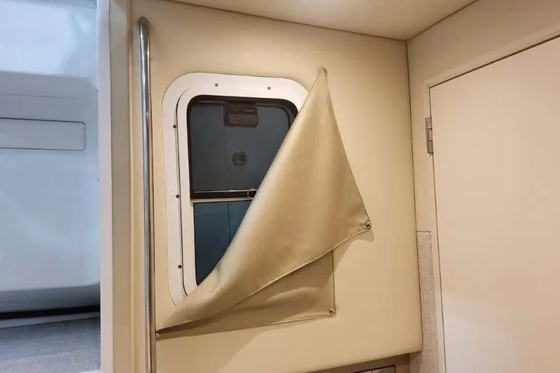 Slide: The Image of Interior view of a 2027 Formula 360 Crossover Bowrider I/O window with beige curtain. - 64