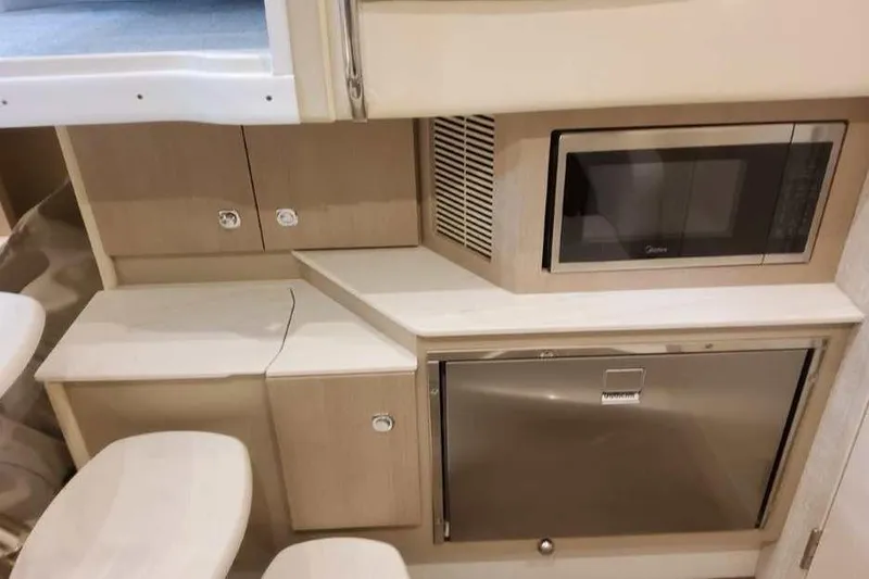 Slide: The Image of Compact kitchenette in 2027 Formula 360 Crossover Bowrider I/O with microwave and fridge. - 63