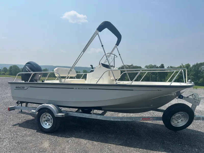 The Image of 2025 Boston Whaler 150 Montauk boat on trailer, parked outdoors under clear sky. - 0