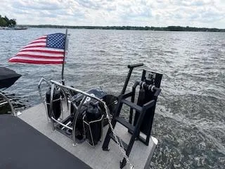 Slide: The Image of 2023 Barletta Corsa 23 UCA pontoon boat with American flag on a lake. - 2