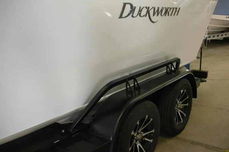 Slide: The Image of 2026 Duckworth 21 Discovery boat on trailer, showcasing sleek design and dual wheels. - 18