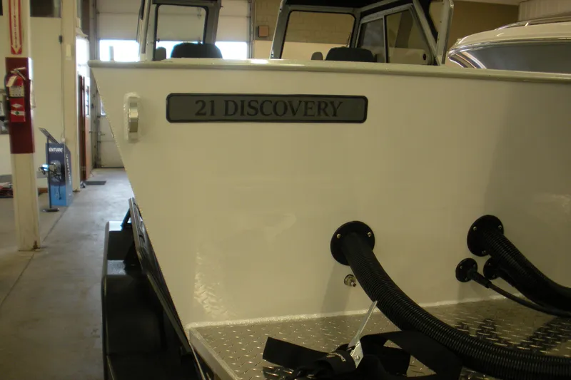 Slide: The Image of Duckworth 21 Discovery 2026 boat in showroom, showcasing sleek design and modern features. - 20