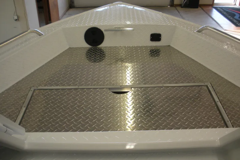 Slide: The Image of Duckworth 21 Discovery 2026 boat interior with diamond plate flooring in a garage setting. - 3